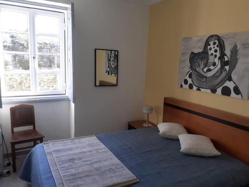 a bedroom with a blue bed and a window at Casa da Figueira in Novelães