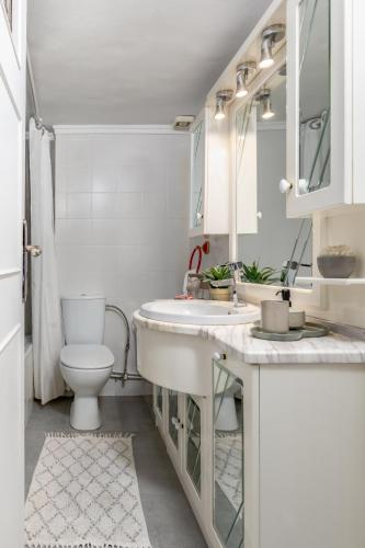 a white bathroom with a toilet and a sink at Chania dream apartment in Chania