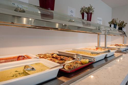 a buffet line with many different types of food at Magique Bleu Suites in Tragaki