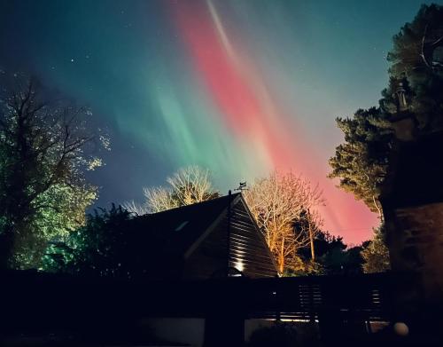 a rainbow in the sky over a house at Pentland Hills Chalet in Edinburgh
