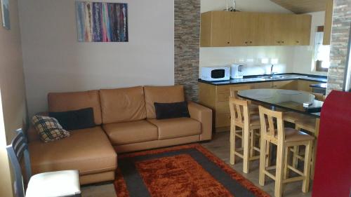 a living room with a couch and a kitchen at Casas da Lagariça in Sortelha