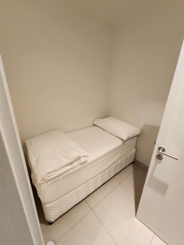 a small bed with white sheets and pillows in a room at Three Bedrooms Apartment at Address Residence Fujairah - AFR3203 in Fujairah