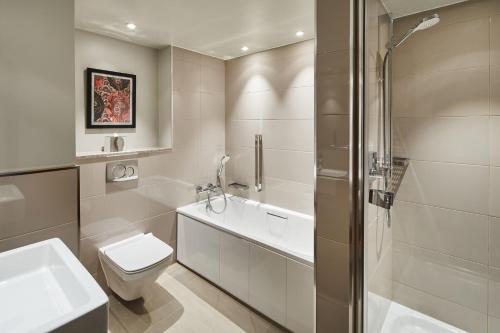 a bathroom with a toilet and a sink and a shower at London Marriott Hotel Kensington in London