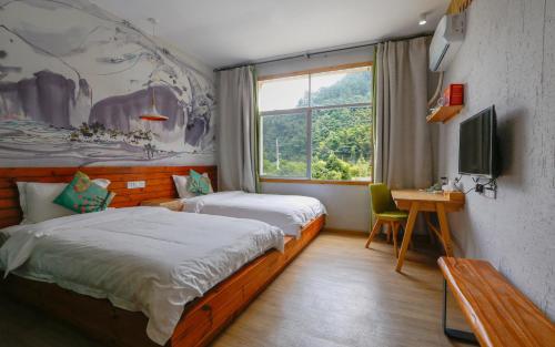 a small bedroom with two beds and a window at Zhangjiajie Forest Park Youth Hostel in Zhangjiajie