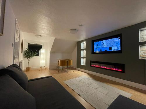 a living room with a fireplace and a tv on a wall at Largs 2 bedroom Apartment in Largs
