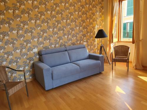a blue couch in a living room with a wall at Casa Pilato in Loreto Aprutino