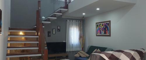 a living room with a staircase and a couch at Temporada Belas Casas in São Pedro