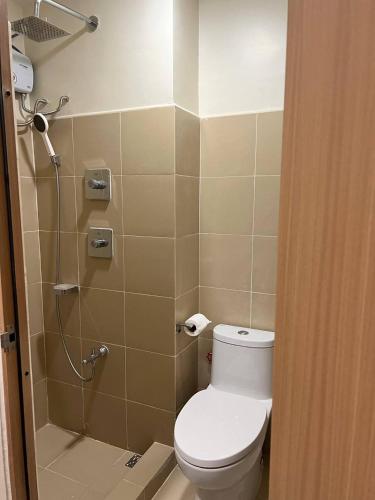 a bathroom with a toilet and a shower at Modern City Escape Near MOA and Airport with Balcony and Fast WiFi in Manila