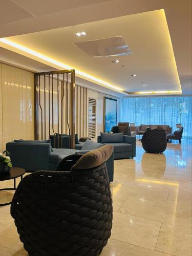 a living room with couches and chairs at Modern City Escape Near MOA and Airport with Balcony and Fast WiFi in Manila