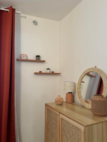 un miroir au-dessus d'une commode dans une pièce dans l'établissement Maison au Cœur de Béziers, à Béziers