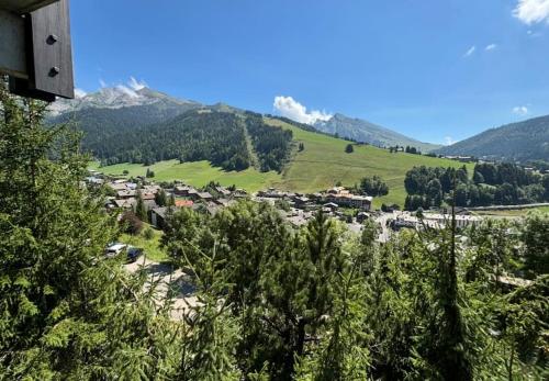 un petit village dans une vallée avec une montagne dans l'établissement La Clusaz Appartement 2 - 4 personnes, à La Clusaz