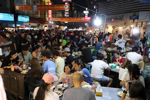 a crowd of people sitting at tables in a market at xx HD Yaowarat Road BKK in Samphanthawong
