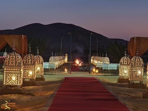 a room with a red carpet and a tent with lights at Asafar Luxury Camp in Merdani