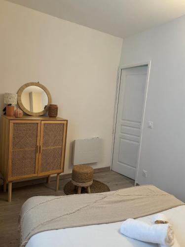 - une chambre avec un lit, un miroir et une commode dans l'établissement Maison au Cœur de Béziers, à Béziers