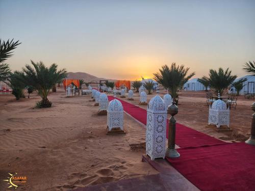 a row of white chairs on a red carpet in the desert at Asafar Luxury Camp in Merdani