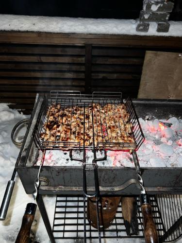 a grill with some food on it in the snow at Vassfjellet Home in Trondheim