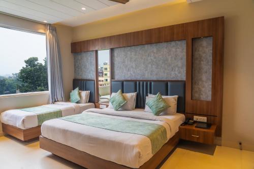 a bedroom with two beds and a window at Hotel Amritsar International 2 min walk from Amritsar Bus Stand in Amritsar