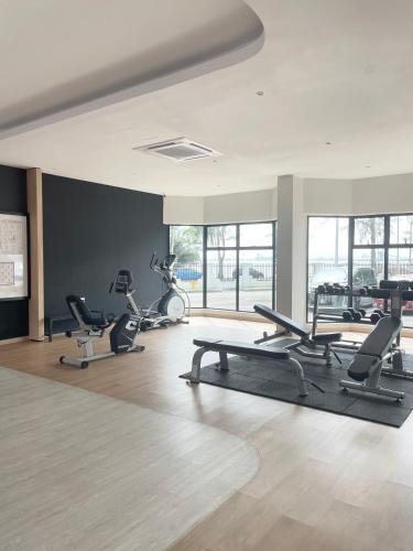 a gym with several treadmills and chairs in a room at Mutiara Melaka Beach Resort by ISRA in Tangga Batu