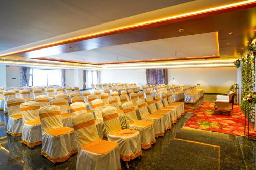 a banquet hall with rows of chairs in a room at Hotel Yathin in Mysore