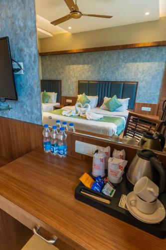 a room with a bed and a table with a kitchen at Hotel Amritsar International 2 min walk from Amritsar Bus Stand in Amritsar