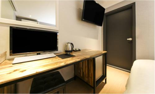 a desk with a computer on top of it in a room at illuwa M in Seoul