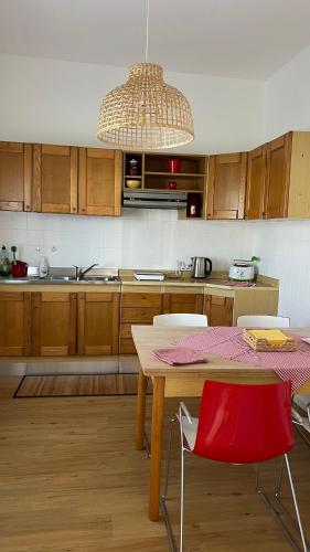a kitchen with a table and a red chair at Appartamento Vittoria in Rovigo