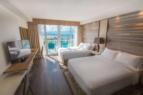 a hotel room with two beds and a television at Resorts World Bimini in Alice Town