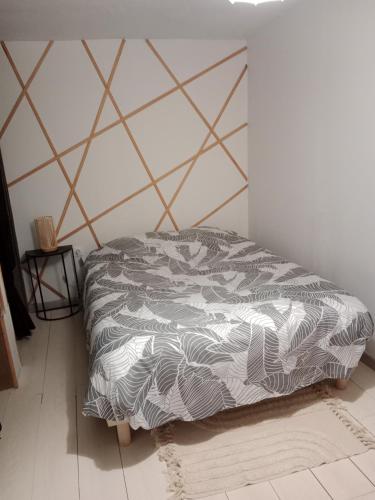 une chambre avec un lit avec une couette noire et blanche dans l'établissement Pounette, appartement sauna T3, Thermes/Centre, à Luxeuil-les-Bains