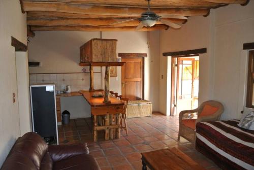 a living room with a couch and a kitchen at Klein Karoo Valley Guest Farm in Amalienstein