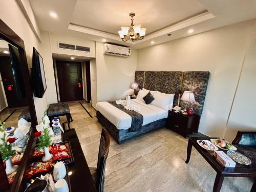 a hotel room with a bed and a dining table at Envoy Continental Hotel, Islamabad in Islamabad