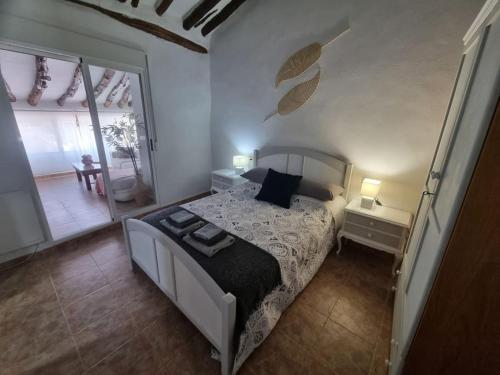 a bedroom with a bed and a large window at Casa Arriba Village House in Zarra in Zarra