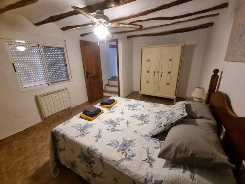 a bedroom with a bed with a blue and white blanket at Casa Arriba Village House in Zarra in Zarra