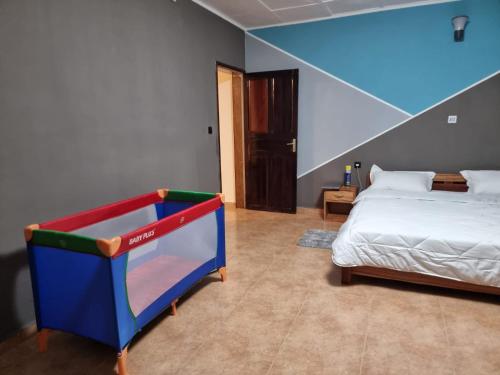 a bedroom with a bed and a blue and red crib at Villa SAIDIA climatisée avec PISCINE in Diego Suarez