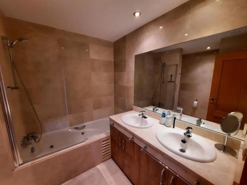 a bathroom with two sinks and a shower and a tub at Las Salinas in Estepona
