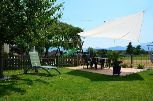 a yard with a table and chairs and a umbrella at Haus Gruber in Attersee am Attersee