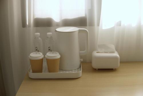 a blender sitting on a counter with two cups of coffee at 大理十二花园民宿 in Dali