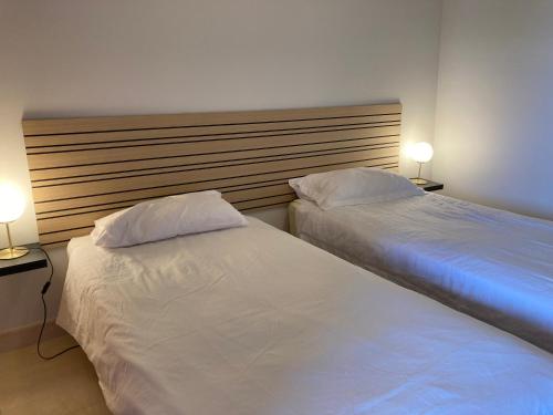 two twin beds in a room with two lamps at Las Salinas in Estepona