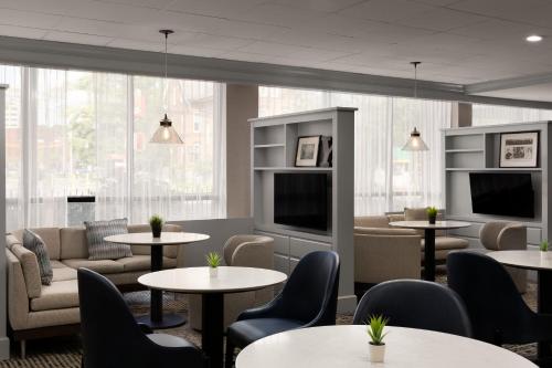 a waiting room with tables and chairs and windows at Courtyard New Haven at Yale in New Haven
