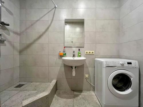 a bathroom with a washing machine and a sink at 4Room Hostel in Kyiv