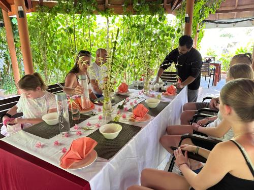 a group of people sitting around a long table at Sabba Beach Suite , Fodhdhoo - Maldives in Velidhoo