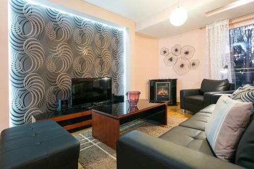 a living room with a couch and a tv at VIP Apartamenty Stara Polana in Zakopane