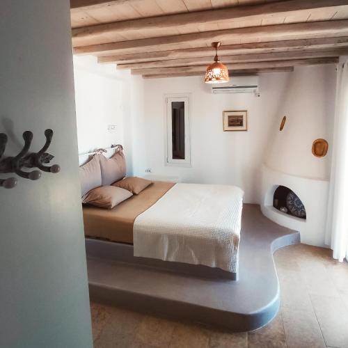 a bedroom with a bed in a white room at Panormos Art Villas & Suites in Panormos