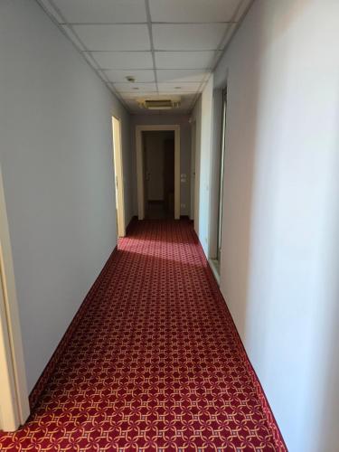 an empty hallway with red flooring in an office building at Hotel Marco Polo Airport hotel in Campalto
