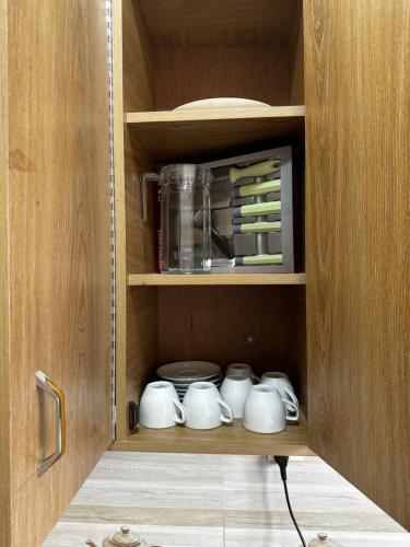 a cupboard with tea cups and a blender at Creative Palace in Nārāyanganj