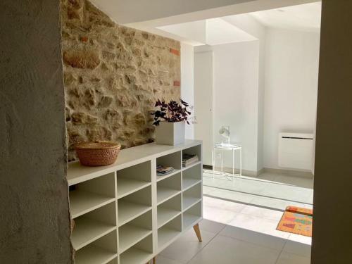 un salon avec un mur en pierre dans l'établissement Bulle de nature, à Charmes-sur-lʼHerbasse