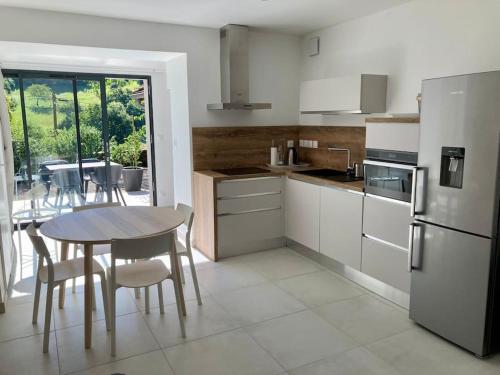 - une cuisine avec une table, une table et des chaises dans l'établissement Bulle de nature, à Charmes-sur-lʼHerbasse