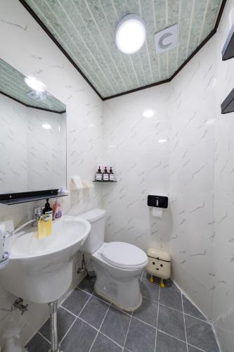 a white bathroom with a toilet and a sink at Anime House in Daejeon