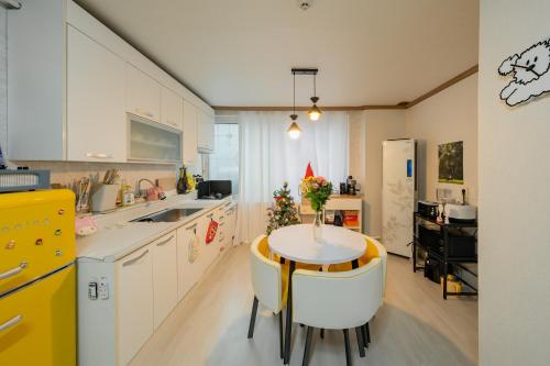 a kitchen with a table with a vase of flowers on it at Anime House in Daejeon