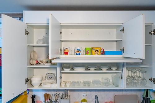 a kitchen cabinet filled with dishes and other kitchen items at Anime House in Daejeon