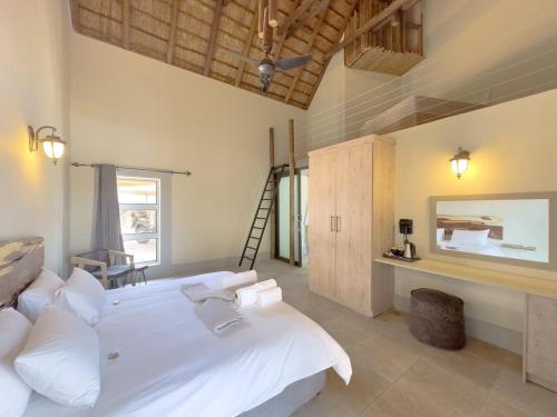 a bedroom with a large white bed in a room at Tebuah Private Lodge, Mabalingwe in Mabula